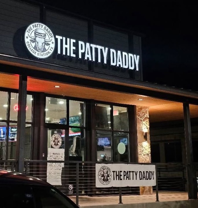 The Patty Daddy storefront lit up at night